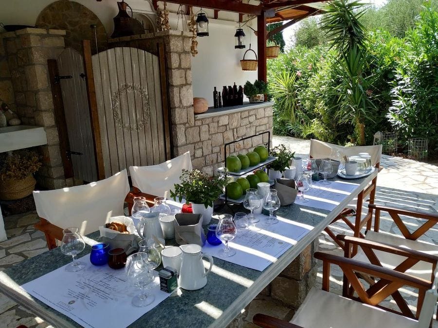 table with green apples and glasses on the terrace covered with wooden beams at Evonymon outside